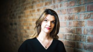 Im Bild siehst du Barbara Blaha und im Hintergrund eine Mauer.