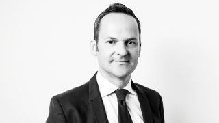 Das Bild zeigt Franz Schellhorn mit Anzug und Krawatte in einem schwarz weiß Foto.