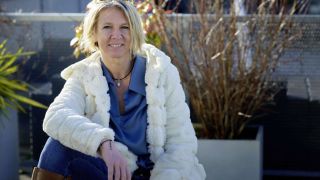 Eva Gallacher lächelt in die Kamera. Die Psychotherapeutin hat kurze blonde Haare.