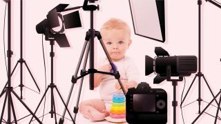 Im Bild siehst du ein kleines Kind mit Spielzeug sitzen. Drum herum befinden sich Kameras mit Stativen und Lichtern.