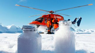 Man sieht einen Hubschrauber und Schnee in Probengläsern