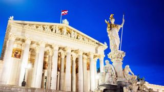 Im Bild sieht man das österreichische Parlament von außen mit dem Himmel im Hintergrund.