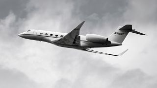 In diesem schwarz-weiß Bild sieht man einen Privatjet mit der Aufschrift N5IIDB. Der Himmel ist bewölkt.